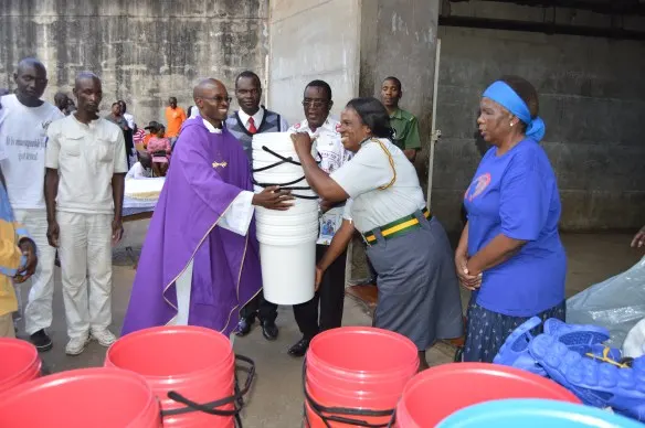 Its all smiles as Fr. Kunaka hands over donated items to (P.O.C.W) Mrs. Mutasa.JPG