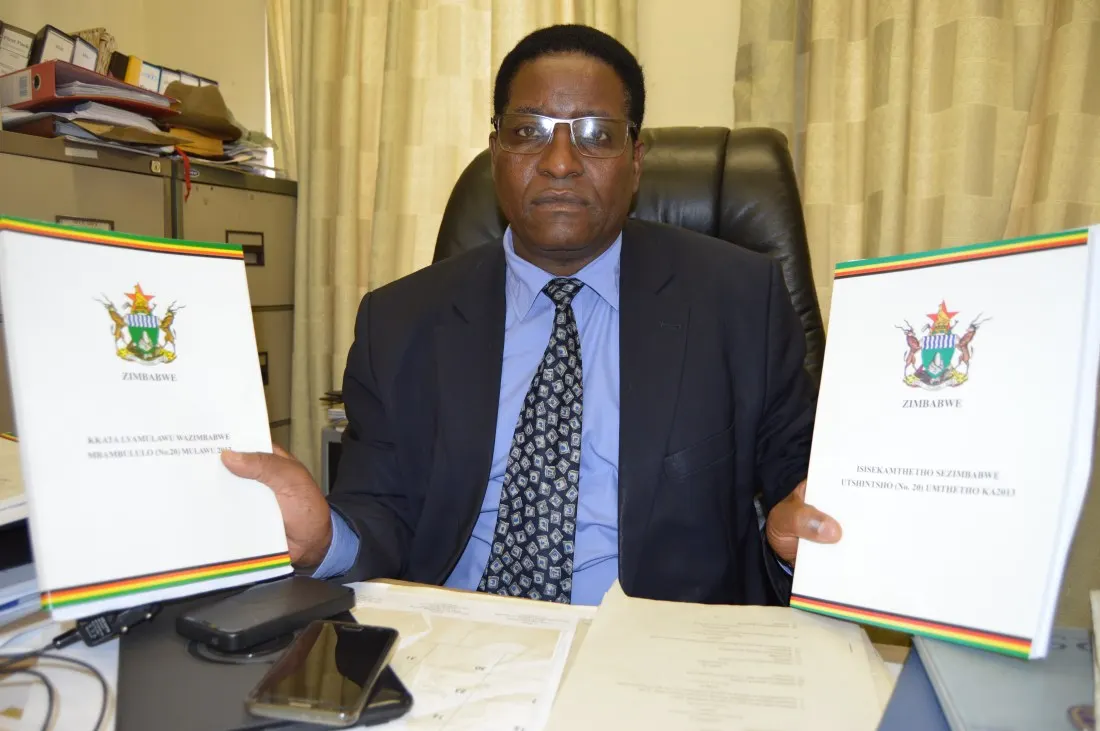 ZCBC, Catholic Parliametary Liaison Coordinator, Fr. Edward Ndete, shows documents of the translated version..JPG