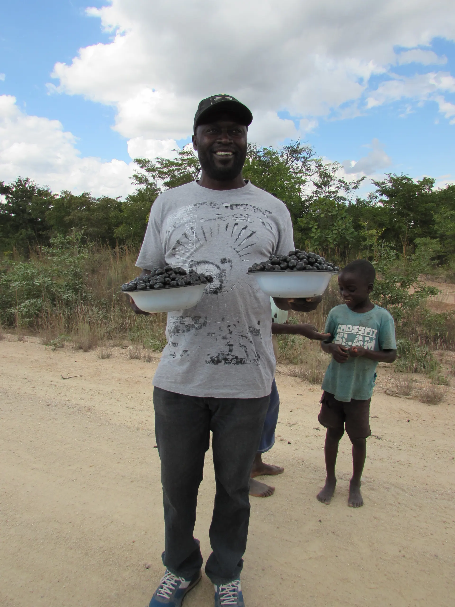All smiles; Mr. Robert Chukucha poses for a picture after buying black berries (Tsubvu) from the young entreprenours.