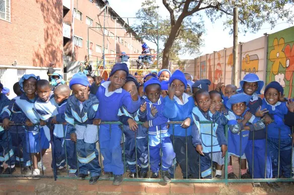 Children at Nenyere Day Care Centre crowd to have a photo.