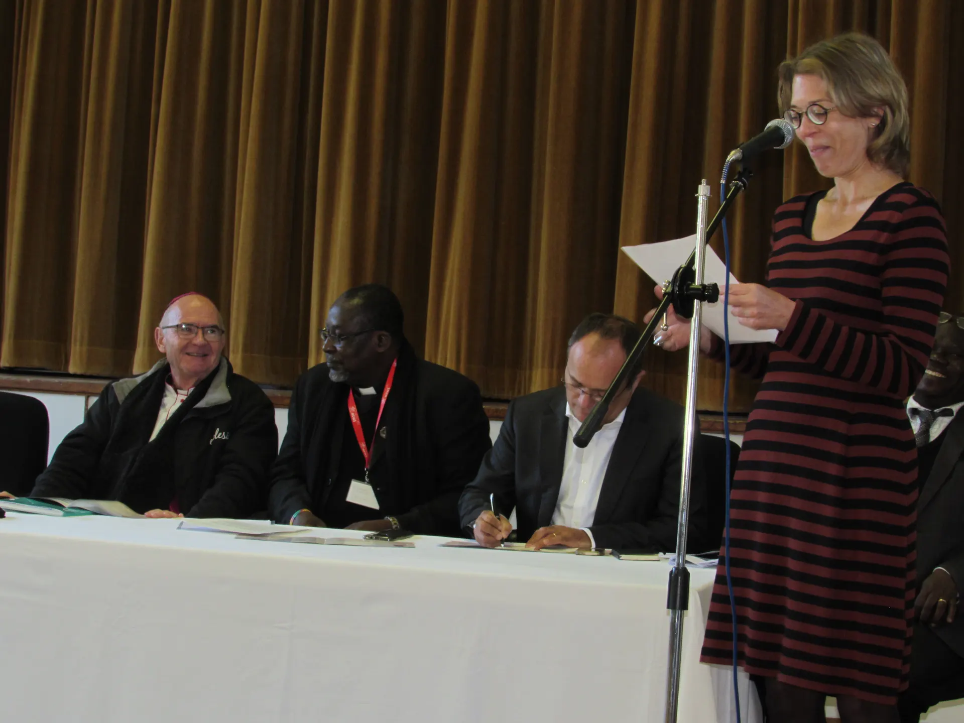 CAMECO representative, Petra Stamen makes a presentation while other delegates including Archbishop Brislin pay attention.