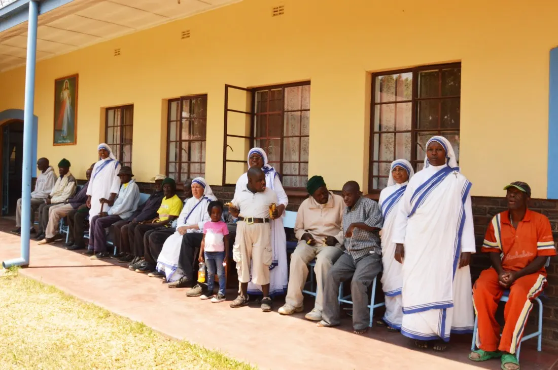 Sisters pose for a picture with some of the inmates at Mother Theresa's Home