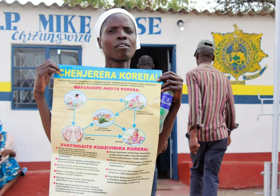 A woman displays a banner encouraging people to fight against cholera in Chitungwiza.