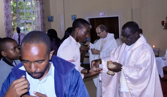archbishop robert ndlovu of the archdiocese of harare (right) and bishop paul horan of mutare distribute holy communion to pilgrims to panama during a farewell mass at rockwood spiri