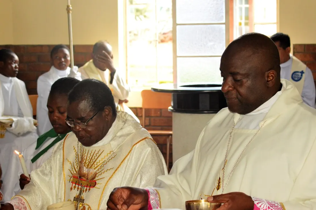Bishop Bhasera (left) and Bishop Mupandasekwa distribute holy communion during mass
