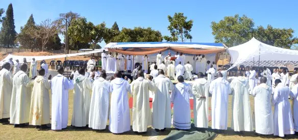 Priests encircle the ordinands while Bishop Bhasera prays over them.